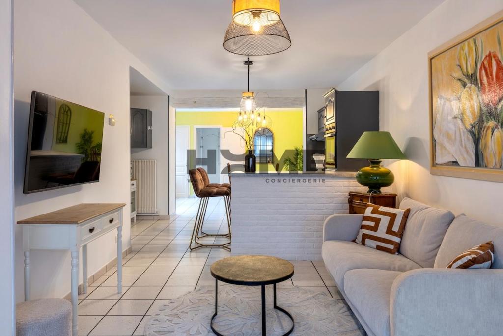 a living room with a couch and a table at Family House in Caudry
