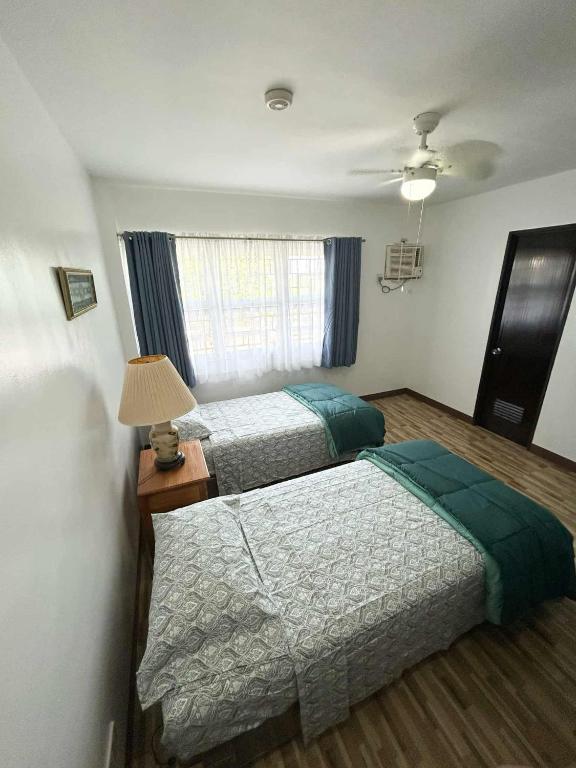 a hotel room with two beds and a window at Domus Florum Travellers Inn in Legazpi