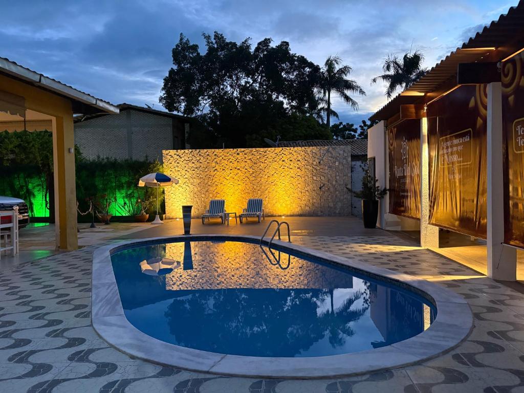 a swimming pool in a backyard at night at Ruta Del Sol in Mossoró
