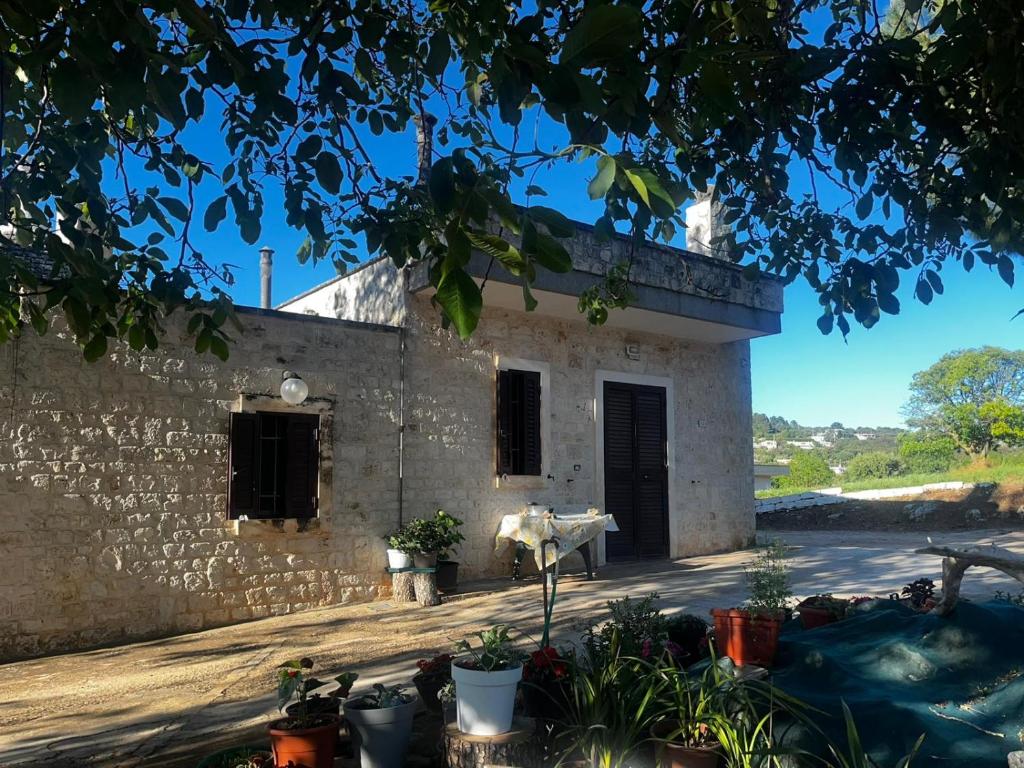 an external view of a building with a table and plants at Casa Angelica, comoda casa nella campagna pugliese in Fasano