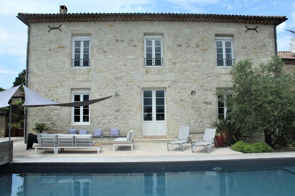 a house with a swimming pool in front of a building at Le Marancènes in Laroque-Timbaut