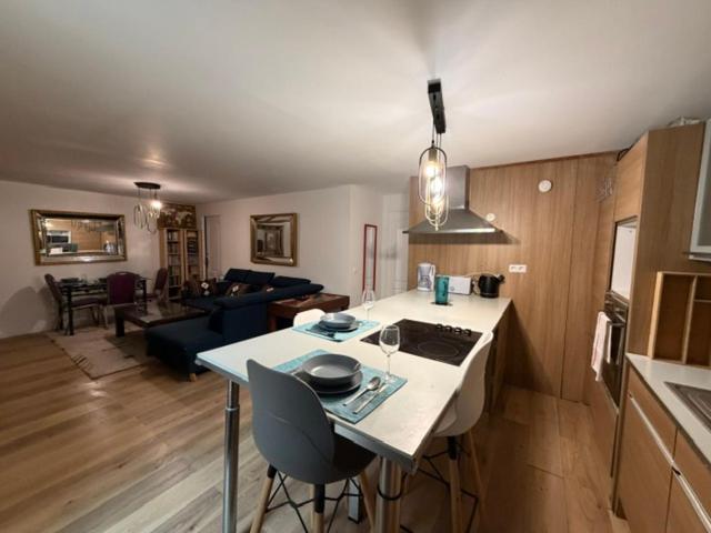a kitchen and living room with a table and a counter top at Disney Harmony Flat in Saint-Thibault-des-Vignes