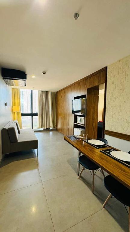 a large living room with a table and a couch at Promoção - Flat em Brasília in Brasília