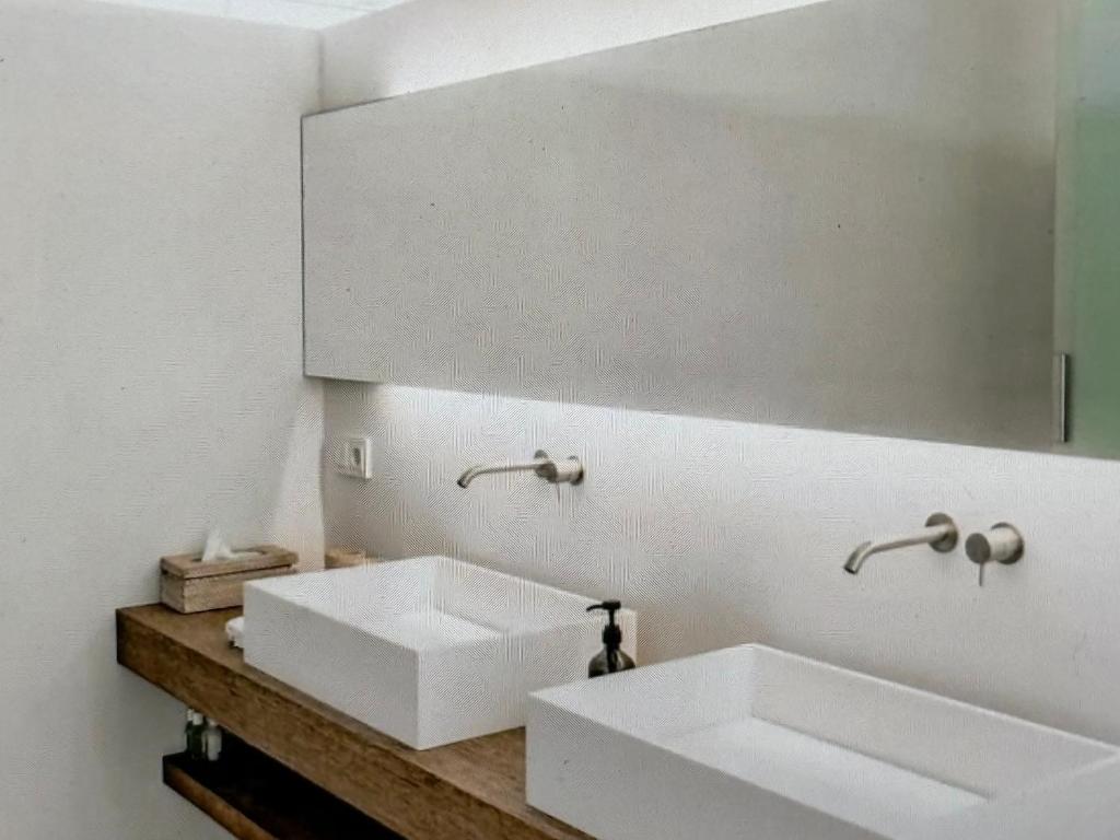 a bathroom with two white sinks and a mirror at Cozy Villa with Pool in Como