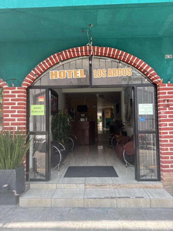 an entrance to a hotel los angeles with tables and chairs at Hotel Los Arcos in Pénjamo