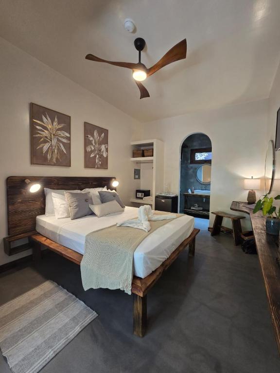 a bedroom with a large bed with a ceiling fan at Jungle Cocoon Boutique Hotel in Caye Caulker