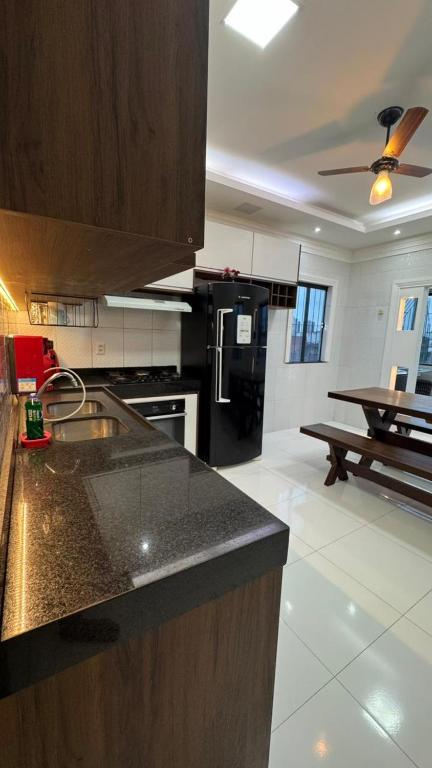 a kitchen with a counter top and a black refrigerator at Casa ampla em belém in Belém