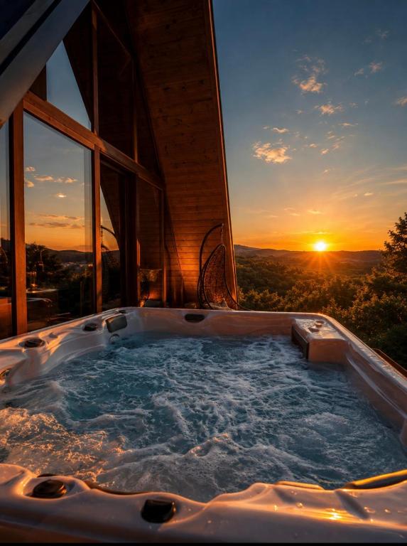 a jacuzzi tub with the sunset in the background at Vila Mila in Vlaška