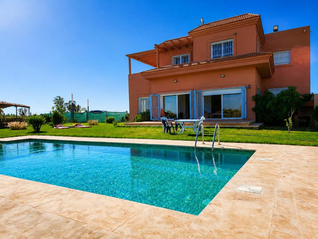 a house with a swimming pool in front of a house at Family fun farm - Évasion Nature - piscine et ferme in Berrechid