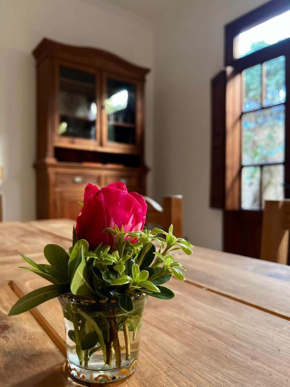 a vase with a pink rose sitting on a table at Tranquilidad en Bragado in Bragado