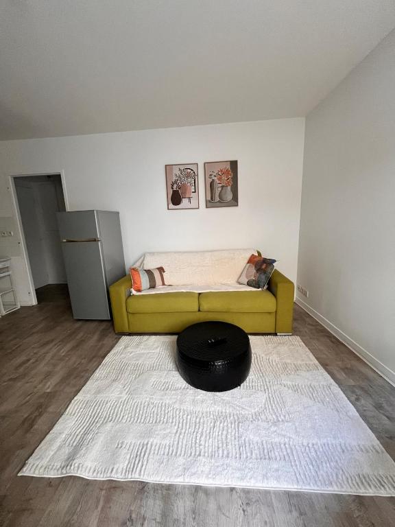 a bedroom with a yellow bed and a white rug at La Parenthèse Calme in Tours