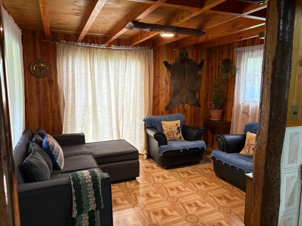 a living room with a couch and two chairs at Parcela Peumayen casa 3 in Pucura