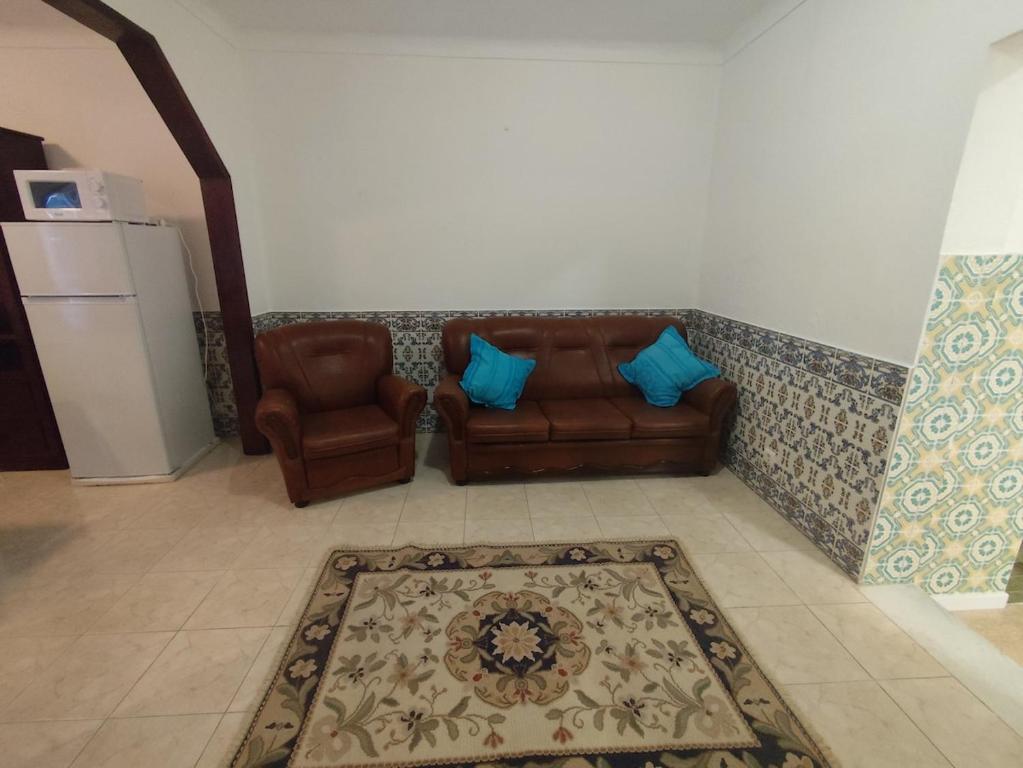 a living room with two couches and a rug at Retiro da Charneca in Fazendas de Almeirim