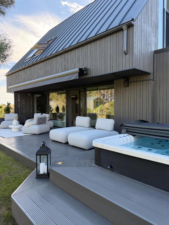a building with beds and a hot tub on a deck at VILLA PIKADI BY THE Baltic Sea in Palanga