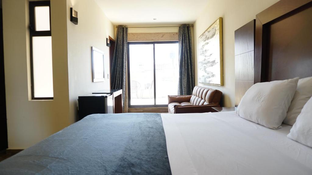 a hotel room with a large bed and a window at Gold Palace Hotel in San Juan de los Lagos