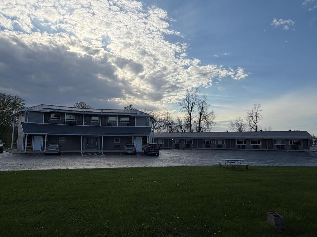 a large building with a grass field in front of it at Aquarius Motel in Perth
