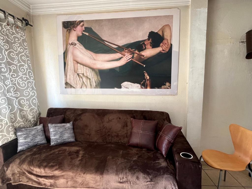 a couch in a living room with a painting on the wall at Birdhouse in Guanajuato