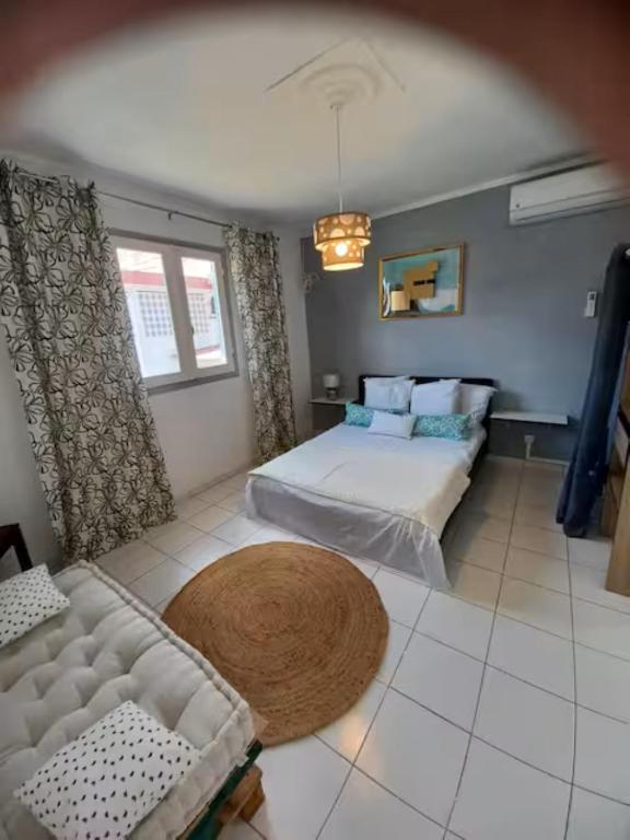 a large bedroom with a bed and a couch at Paradies Caraïbes III in Les Abymes