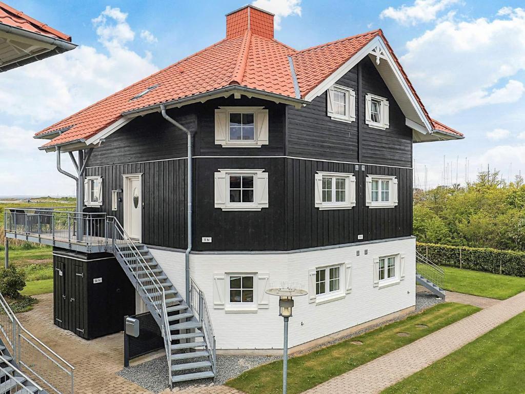 a black and white house with a gambrel roof at 8 person holiday home in Bogense-By Traum in Bogense