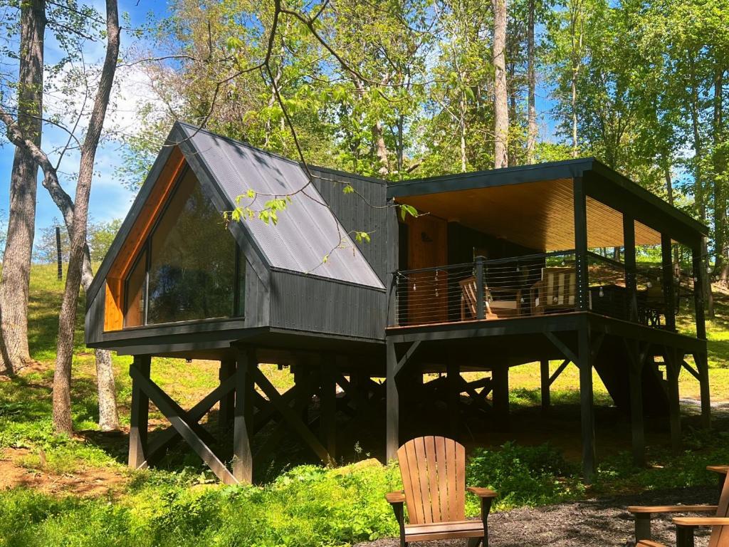 a tree house in the woods with a deck at Bison Farm - Cabin "Loma" in Culpeper