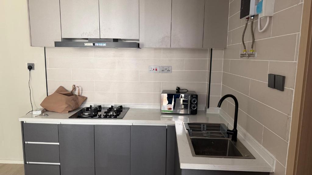 a small kitchen with a stove and a microwave at Leo residences 1 in Eldoret