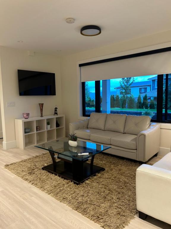 a living room with a couch and a table at Luxury EW Bed & Breakfast in Abbotsford