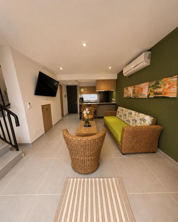 a living room with a couch and a tv at Casa Edén 95 in Ricaurte
