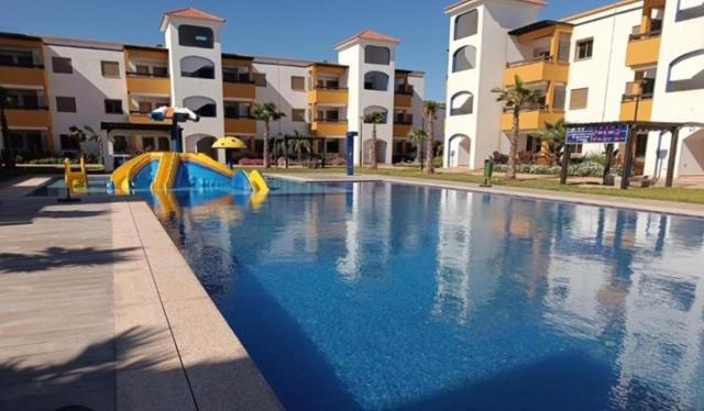 a swimming pool with a slide in front of some buildings at Marinamer 1 in Saïdia