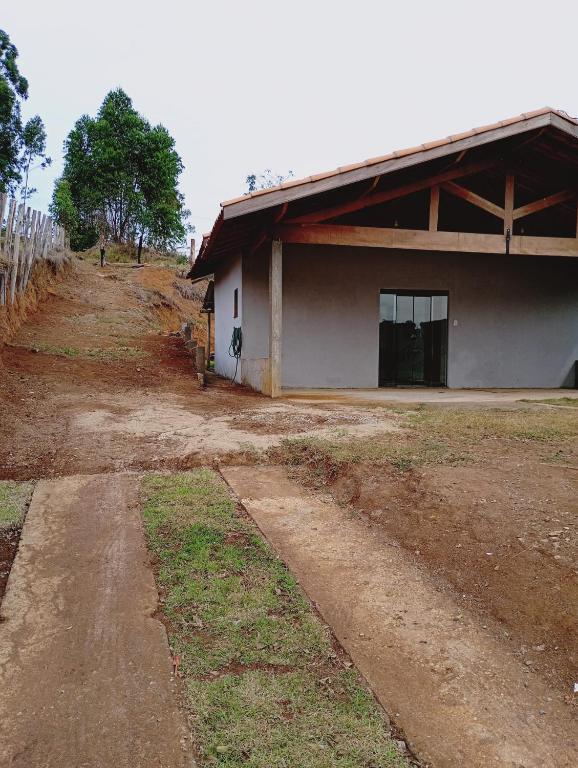 a building with a dirt road in front of it at Recanto da Nonô in Gonçalves