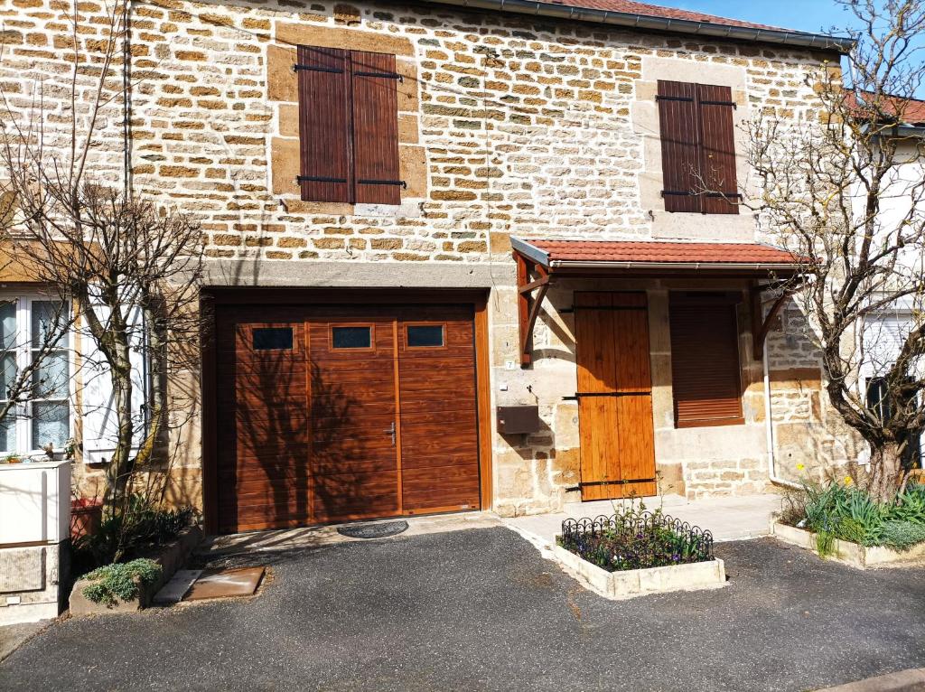 a brick house with two garage doors on it at L'Annexe - Bis in Chalindrey