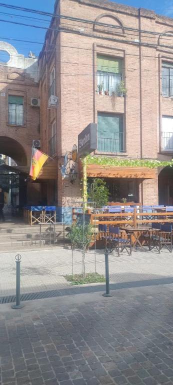 a building with tables and benches in front of a building at Olivos Lujan in Luján