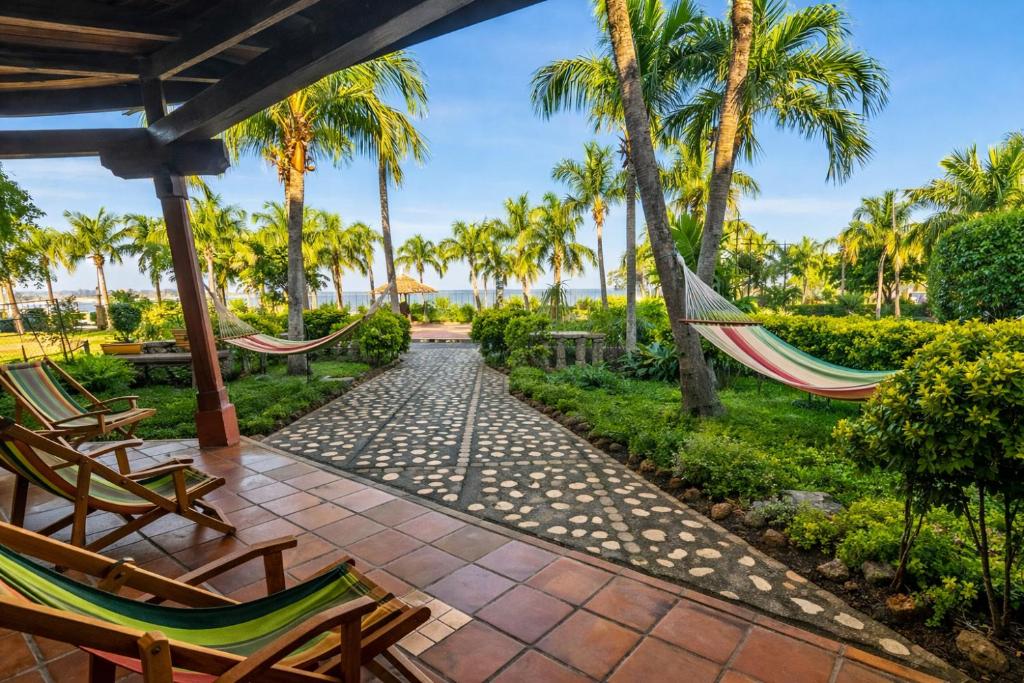 a patio with hammocks and palm trees at Hotel El Maltese - Lakefront in Granada
