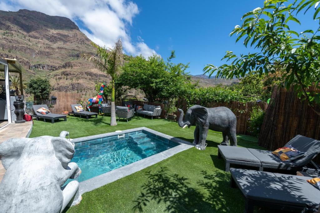 a statue of an elephant standing next to a pool at Oasis fataga 2 in San Bartolomé