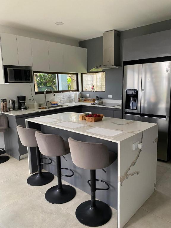 a kitchen with a large island with bar stools at Casa Colibrí in Alajuela