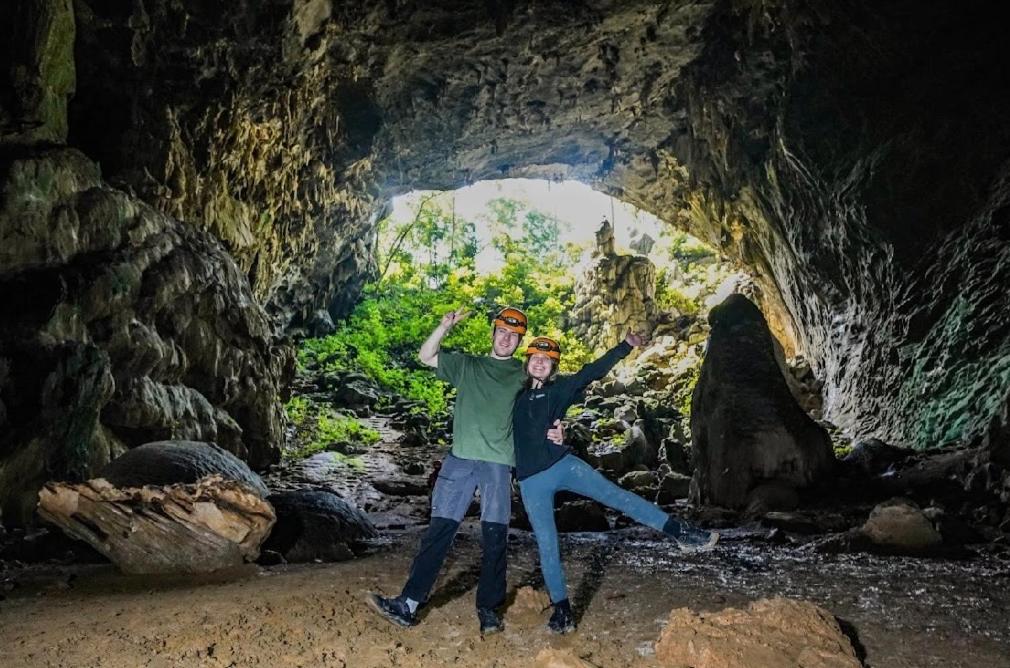 two people posing in front of a cave at Midtown homestay in Phong Nha