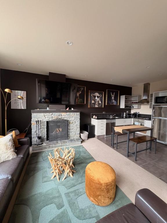 a living room with a couch and a fireplace at Cardrona Alpine Luxe in Cardrona