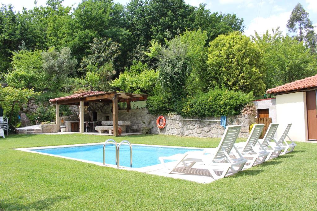 a group of lawn chairs next to a swimming pool at Leiras da Cachada - Gerês in Valdosende