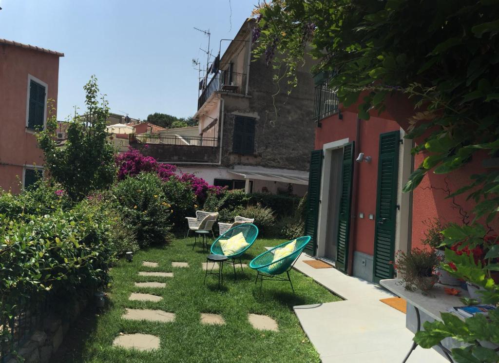 a garden with two chairs and a table and a building at La Casa di Andrea Relais in Monterosso al Mare