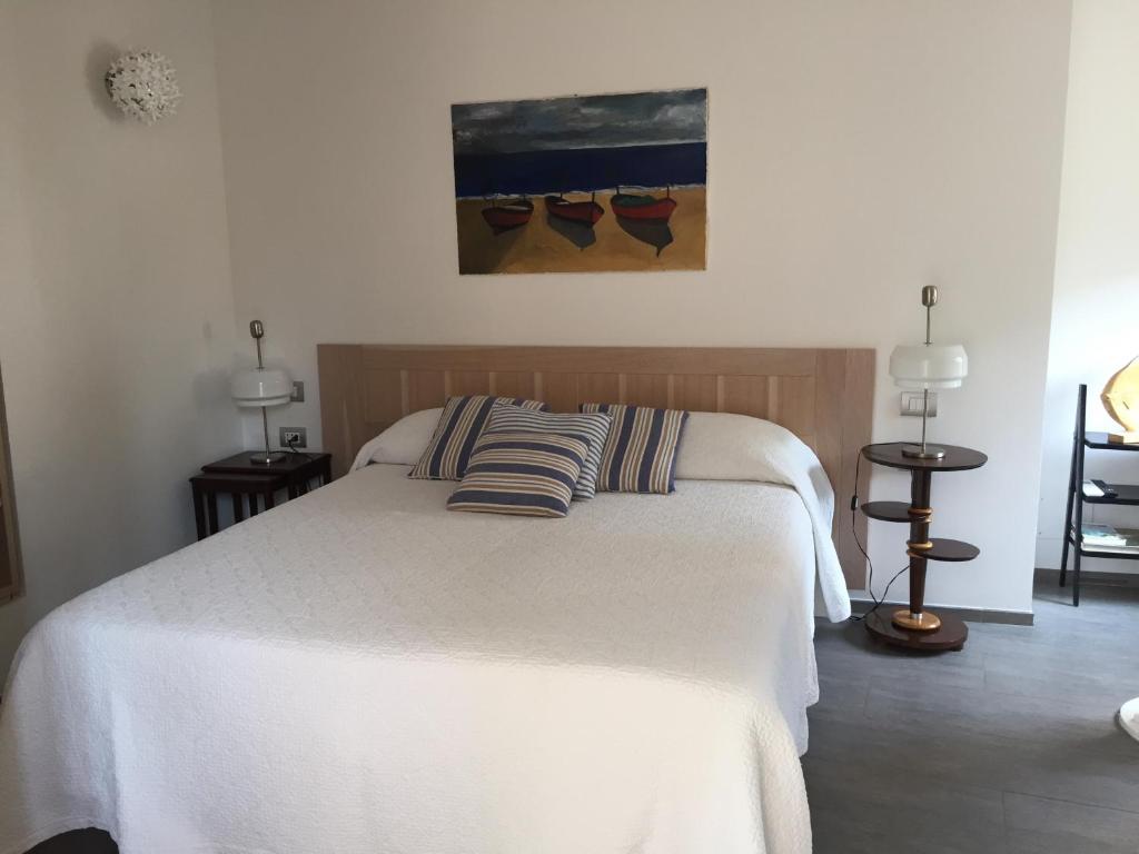 a bedroom with a white bed with two pillows on it at La Casa di Andrea Relais in Monterosso al Mare