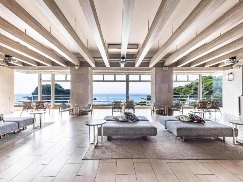 a lobby with couches and tables and windows at il azzurri in Nishiizu