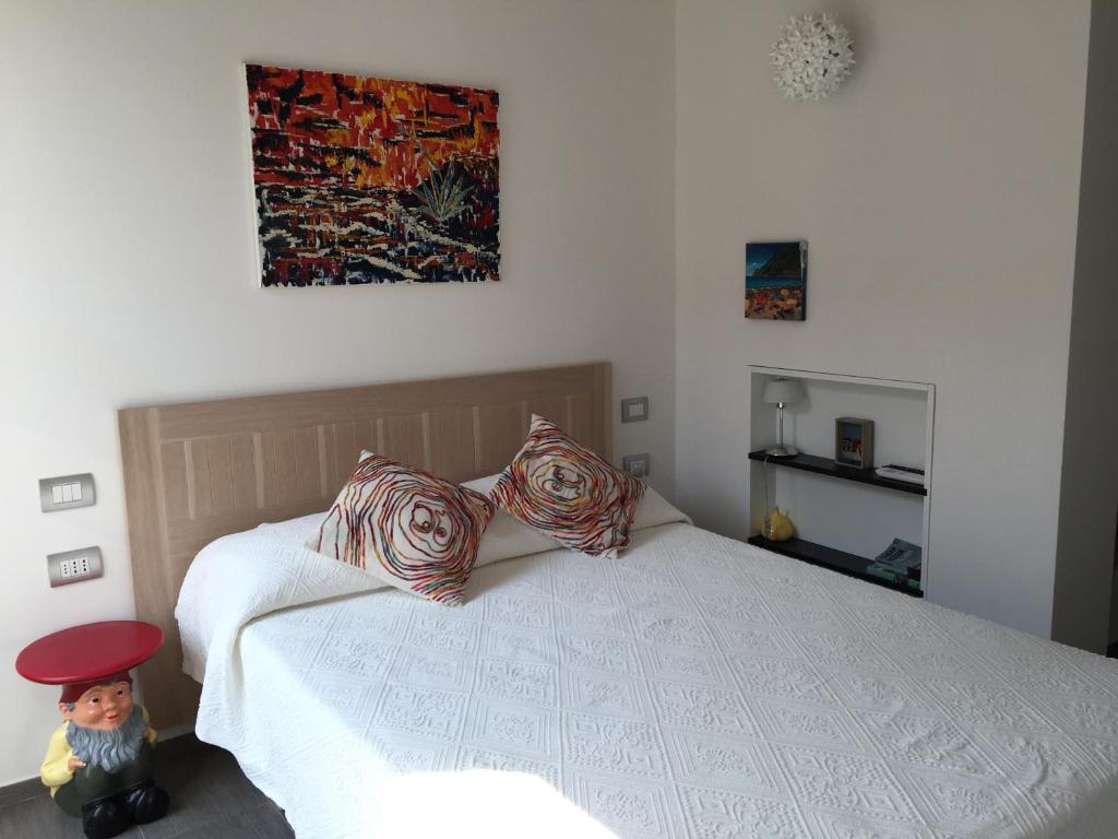 a bedroom with a bed with a doll sitting on it at La Casa di Andrea Relais in Monterosso al Mare