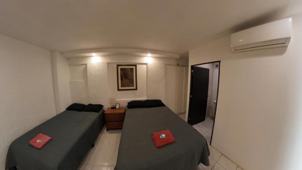a small room with two beds and a hallway at JESAVI Leones in Monterrey