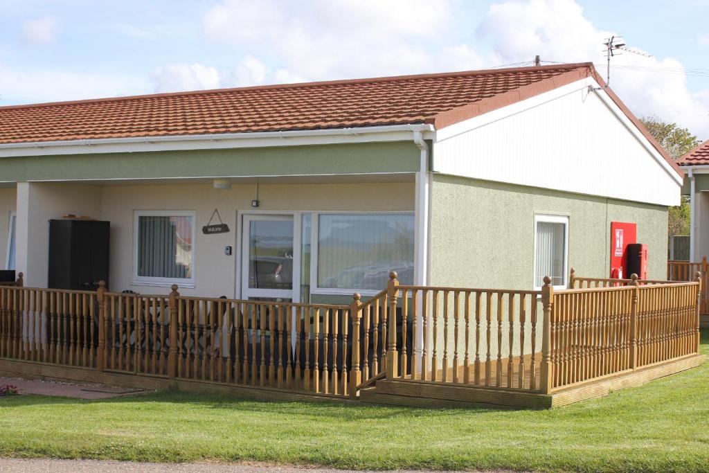 a house with a wooden fence in front of it at Seaview Cottage in Bacton