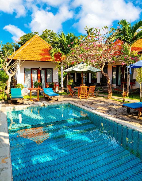a swimming pool in front of a house at Tunjung Kuning Cottage in Nusa Penida