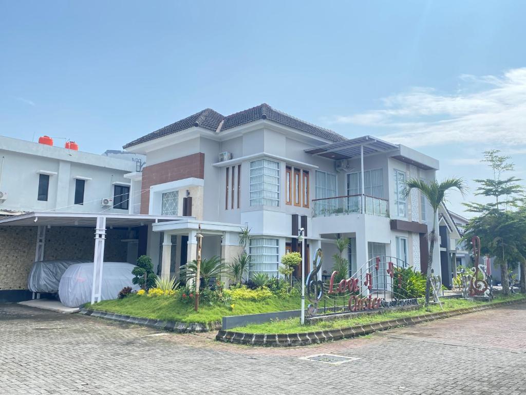 a large white house on the side of a street at Moses Homestay, Yogyakarta in Beran-kidul