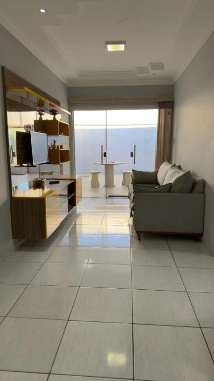 a living room with a couch and a large window at Casa espaçosa com 3 quartos climatizados in Petrolina