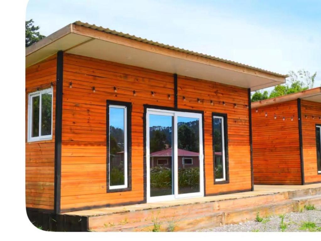a small wooden house with many windows at Esperanza Escape Cabin in Intibucá
