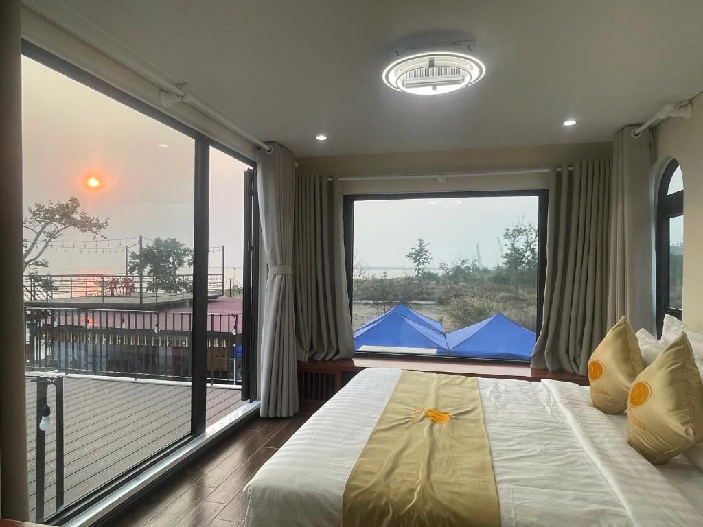 a bedroom with a large bed and a large window at Châu Anh House in Ðố Sơn