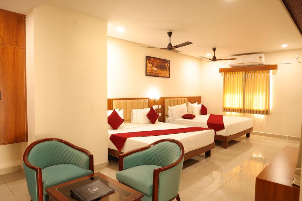 a hotel room with two beds and two chairs at Hotel Nanda Mohan Residency -MSR Manssion Inn in Tirupati