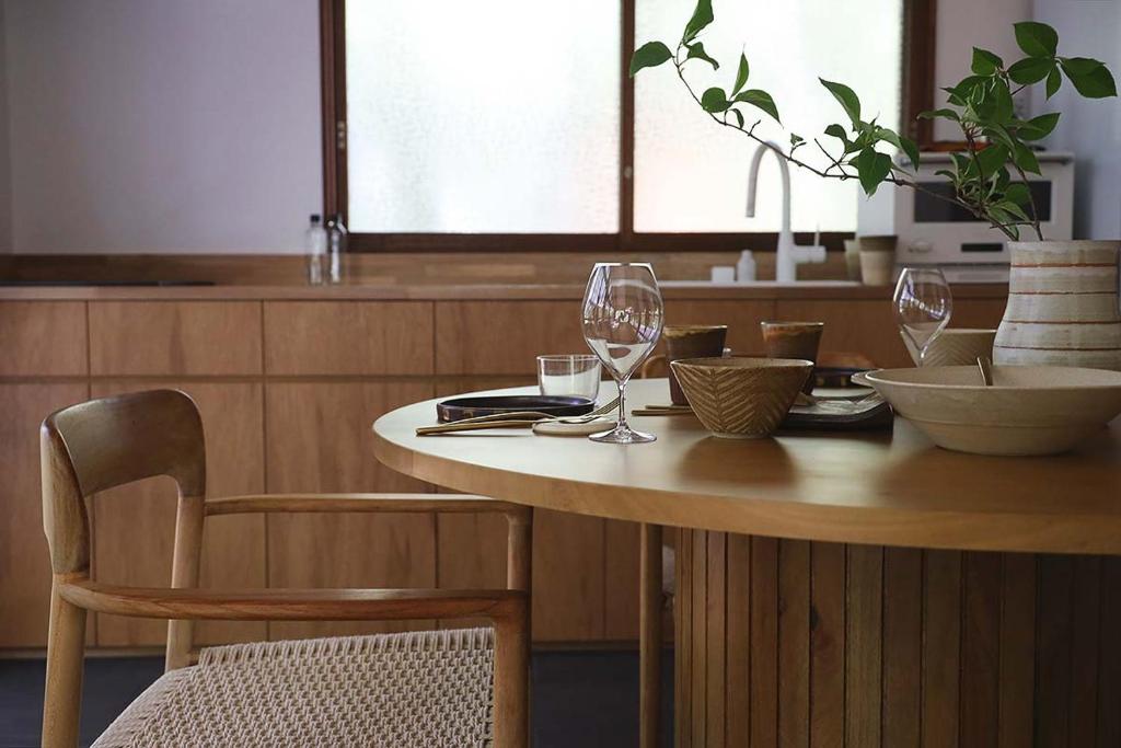a wooden table with two wine glasses on it at The Cabin by Deep Gorge in Kita-karuizawa
